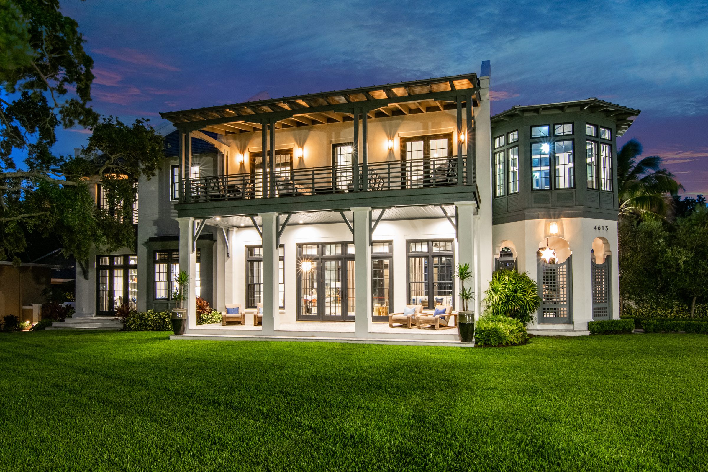 Two-story home with a covered balcony at dusk