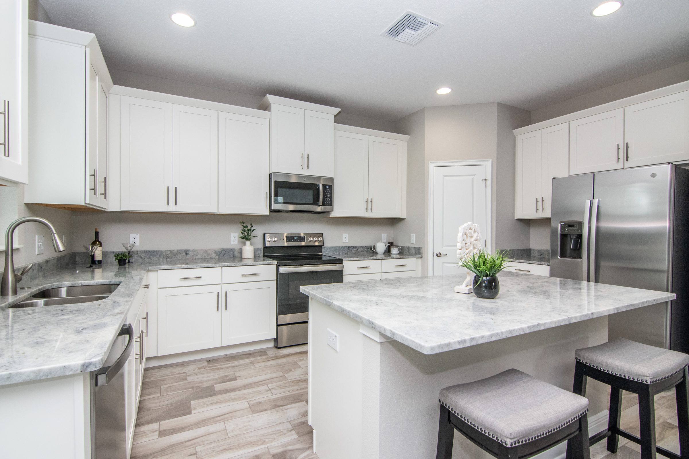 Kitchen with white cabinets and a granite island