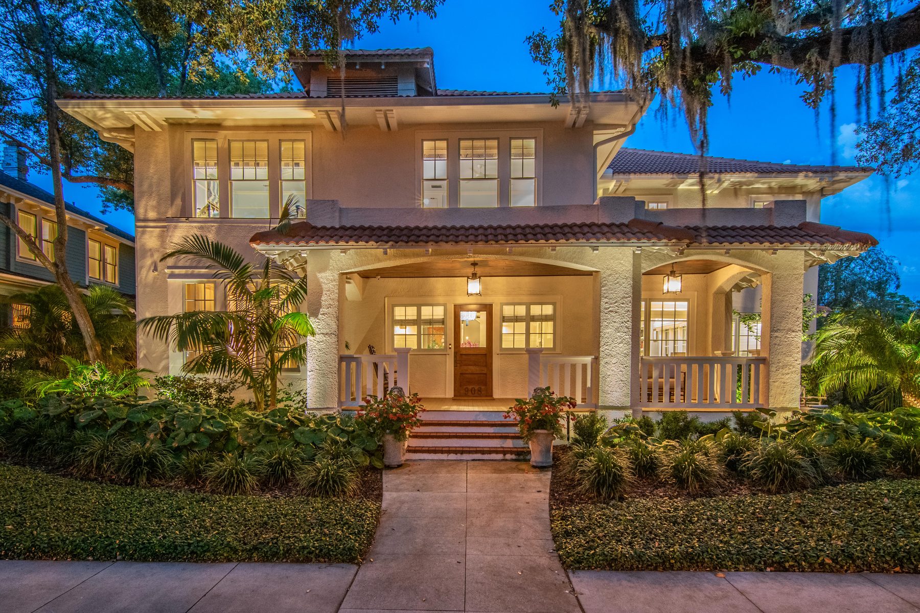 Craftsman-style home with a lit front porch at dusk
