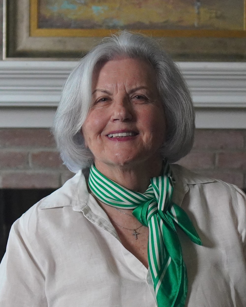 Janice Powell smiling at the camera in front of a fireplace